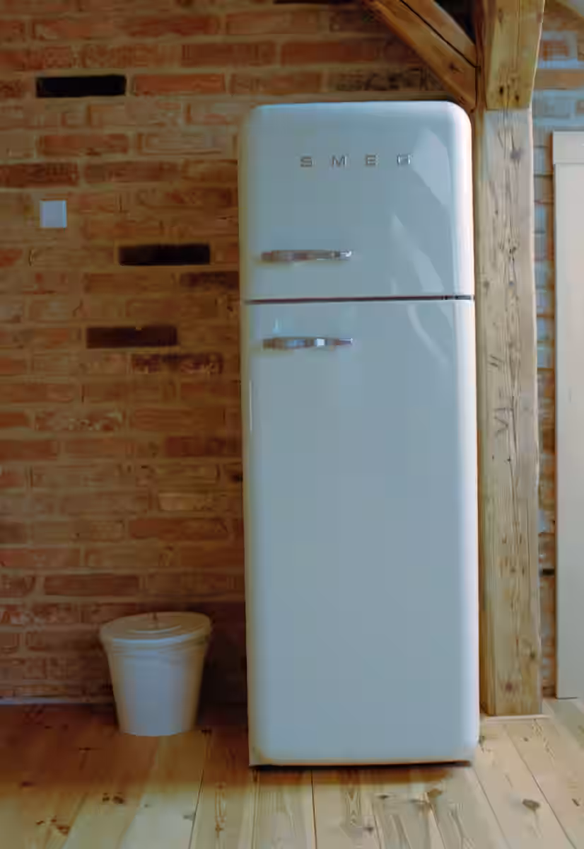 A white refrigerator freezer sitting on top of a wooden floor